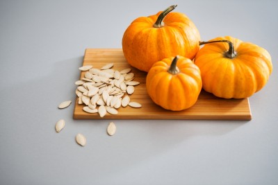 Closeup Of Miniature Pumpkins And Seeds On A Cutting Board