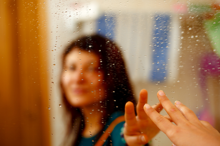 misty reflection of girl in the mirror with water droplets